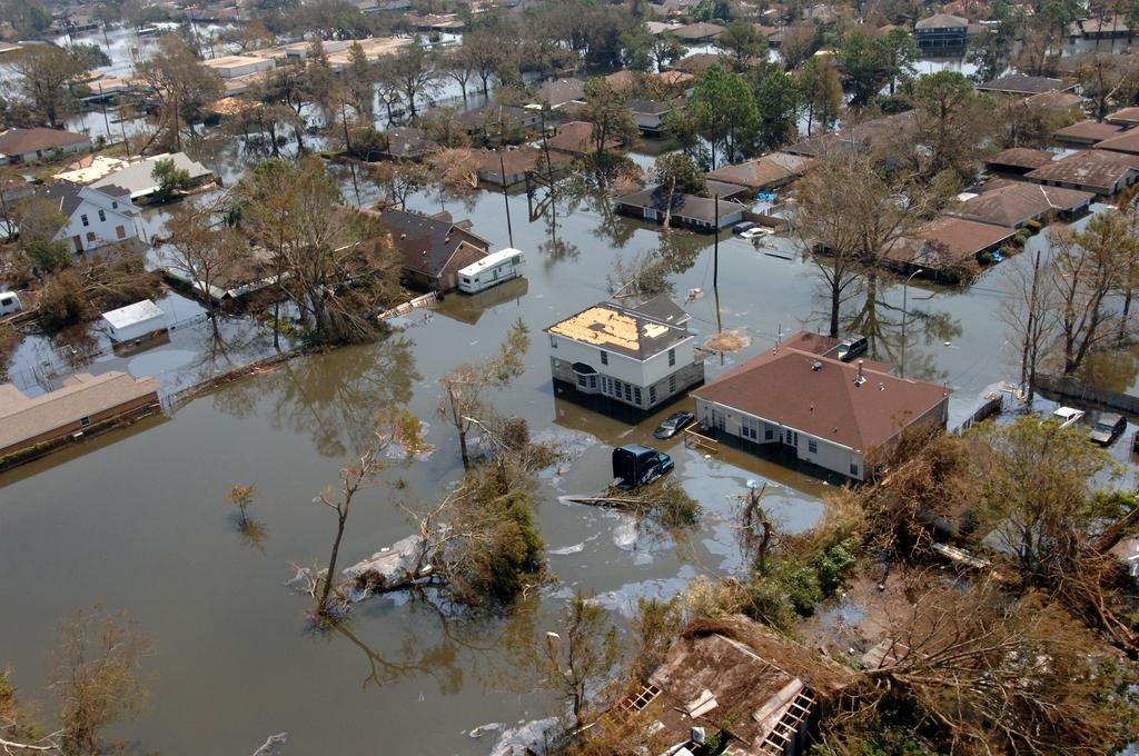 Aerial view of a flooded residential neighborhood with homes surrounded by standing floodwater